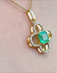 Clover design pendant with a center natural colombian emerald and halo diamonds.