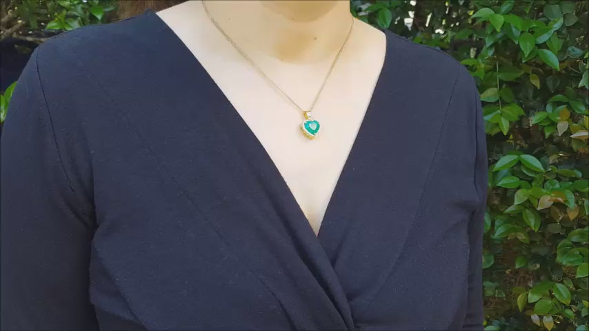 Heart shaped emerald pendant halo diamond in 18k yellow gold.