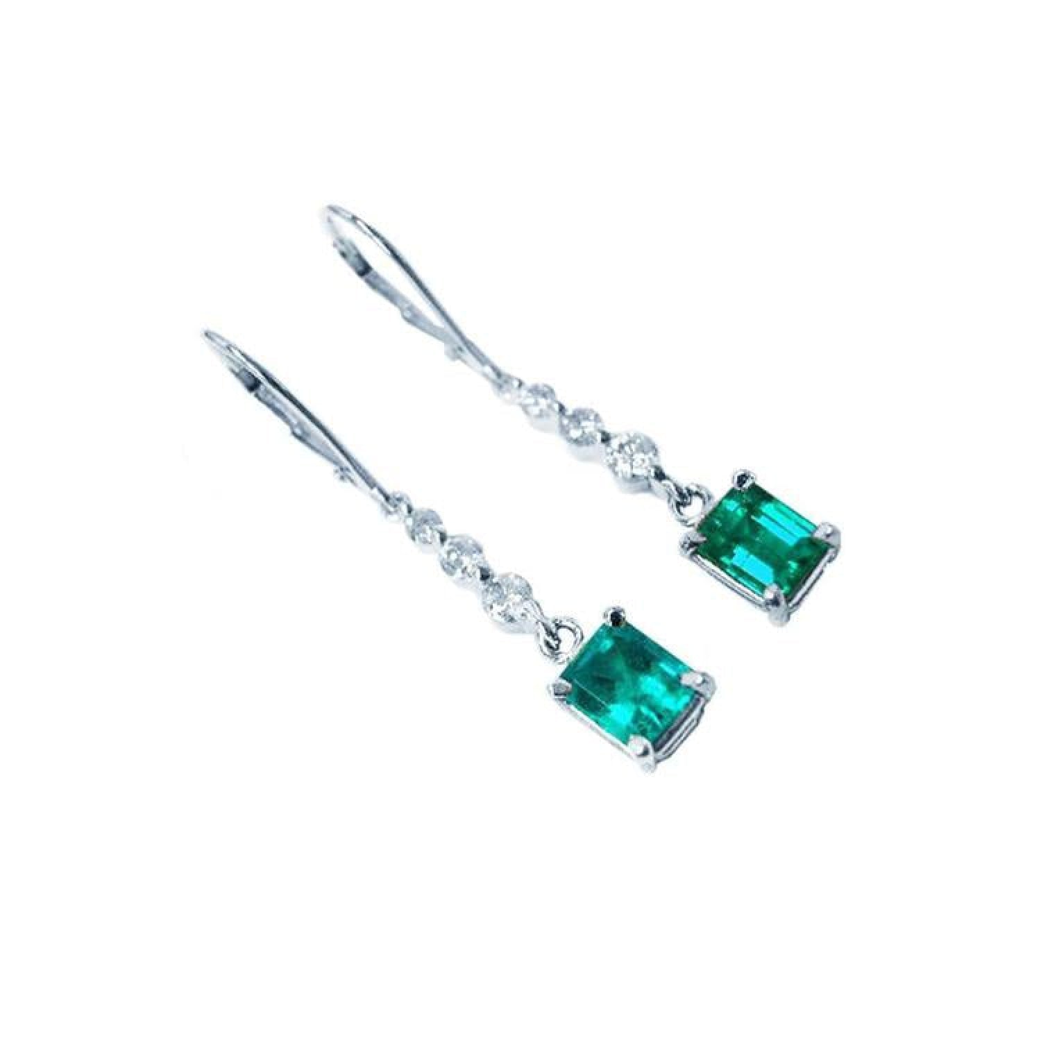 14K white gold dangle earrings with emerald-cut Colombian emeralds and diamond accents.