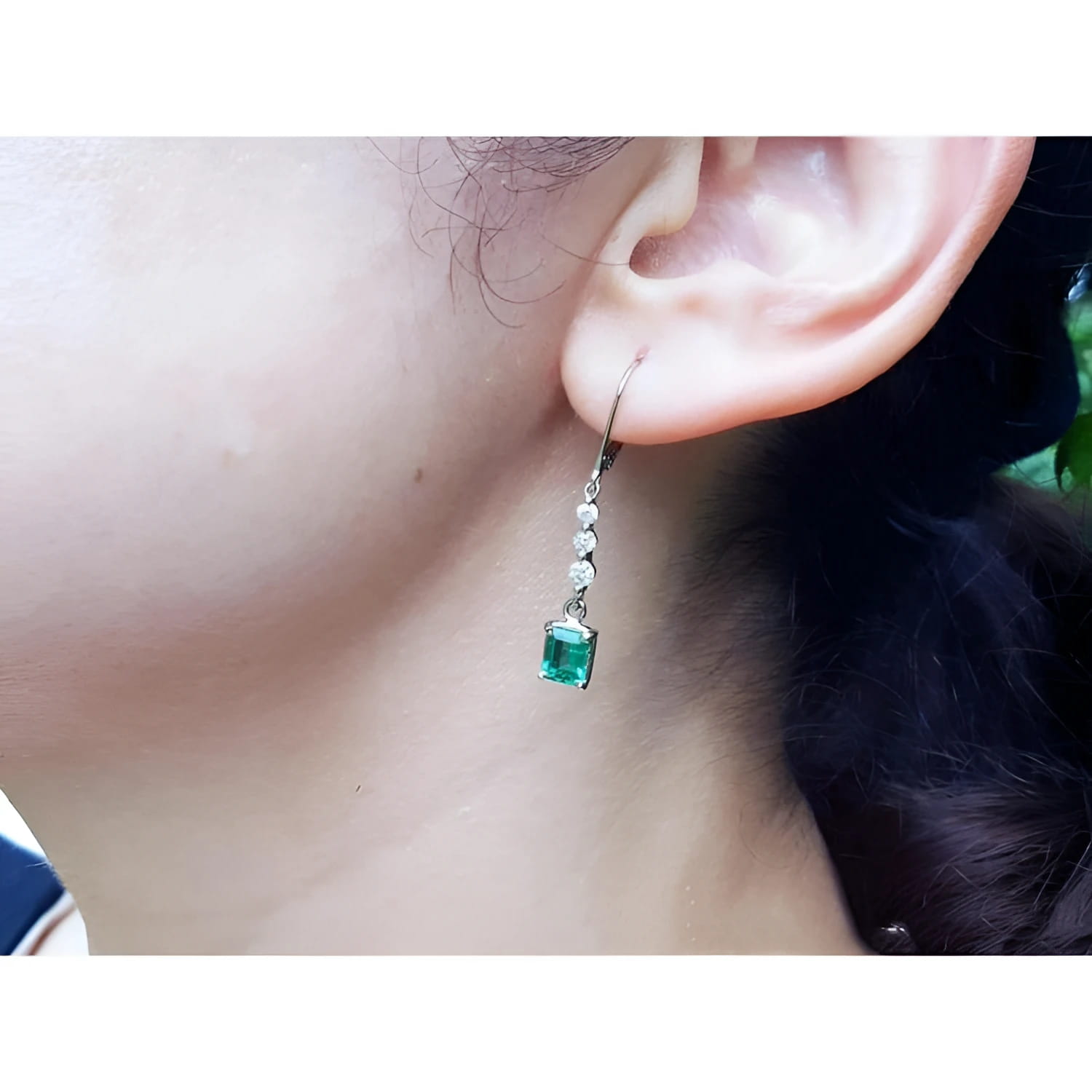 14K white gold dangle earrings with three small diamonds and a square-cut Colombian emerald.
