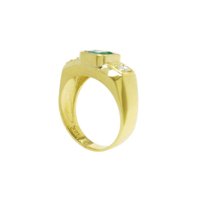 A yellow gold men's emerald ring on a white background