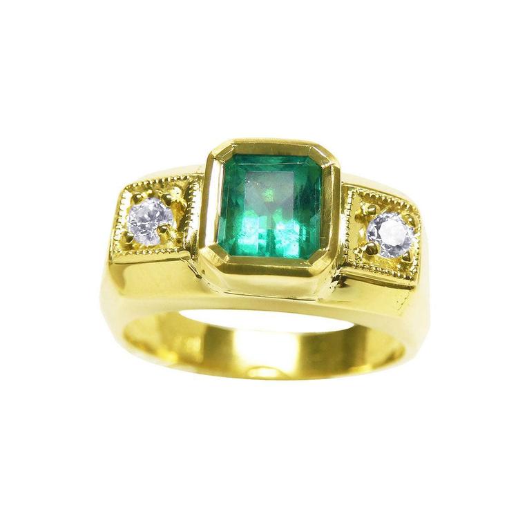 Gold ring for men with a natural emerald and two side diamonds on a topside view.