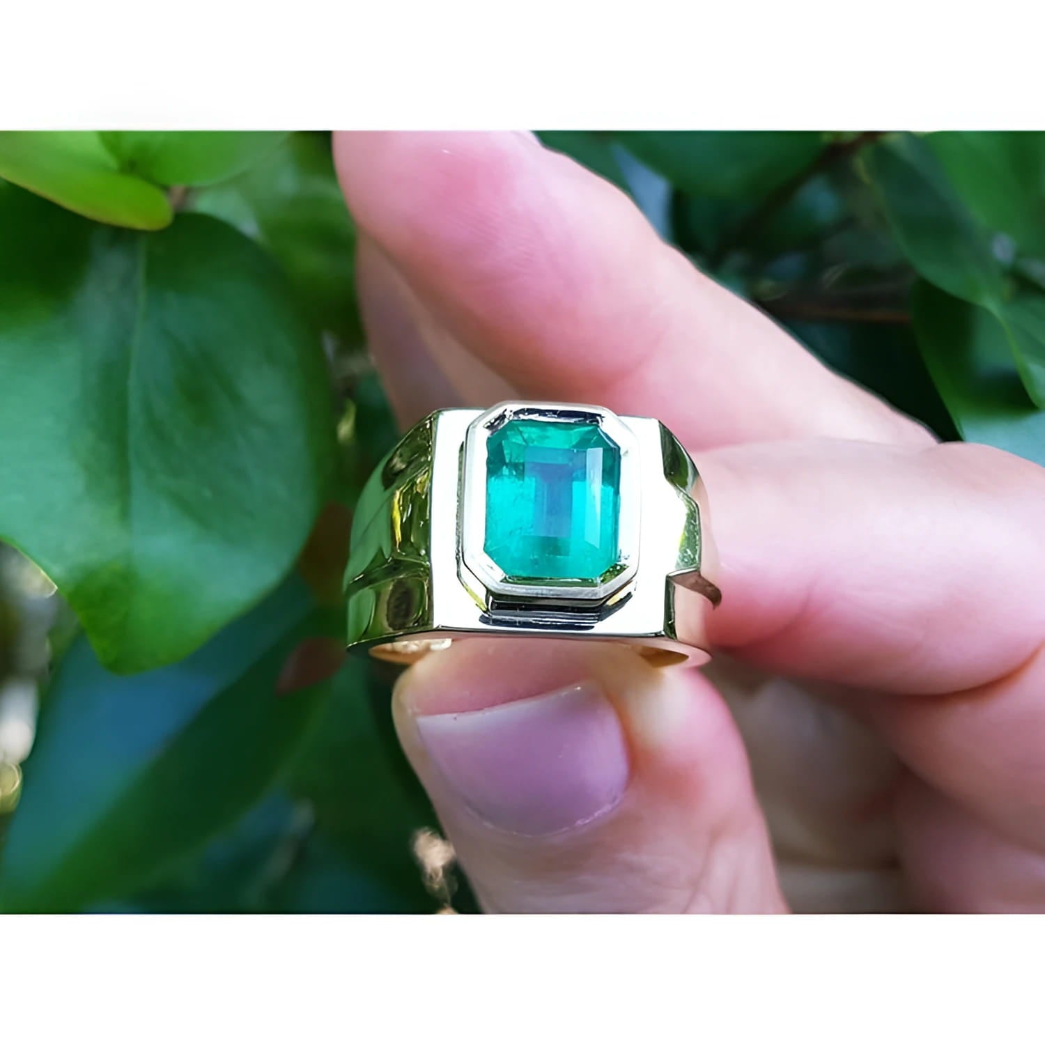 Men's 18K yellow gold solitaire ring with a rectangular Colombian emerald in a bezel setting.
