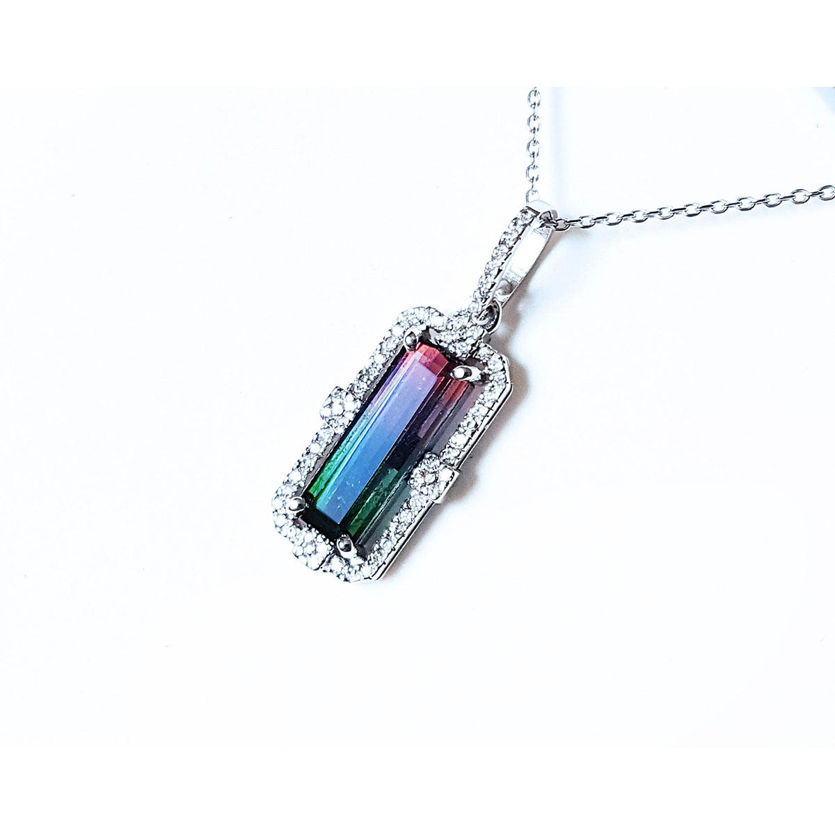 The left side profile of a watermelon tourmaline pendant in white gold and diamonds.