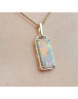 Opal pendant necklace on a person's chest.