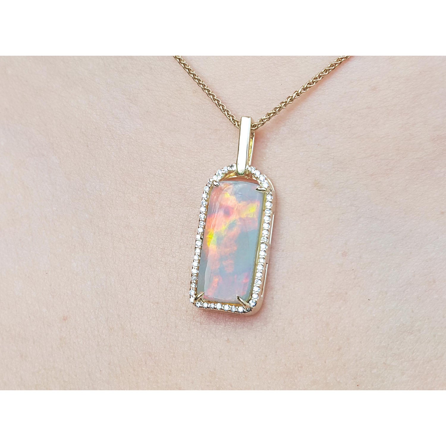 Opal pendant necklace on a beige skin background.
