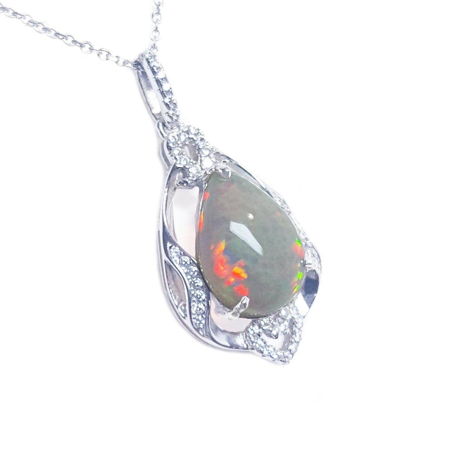 Teardrop-shaped opal pendant with silver chain on a right-side profile view.