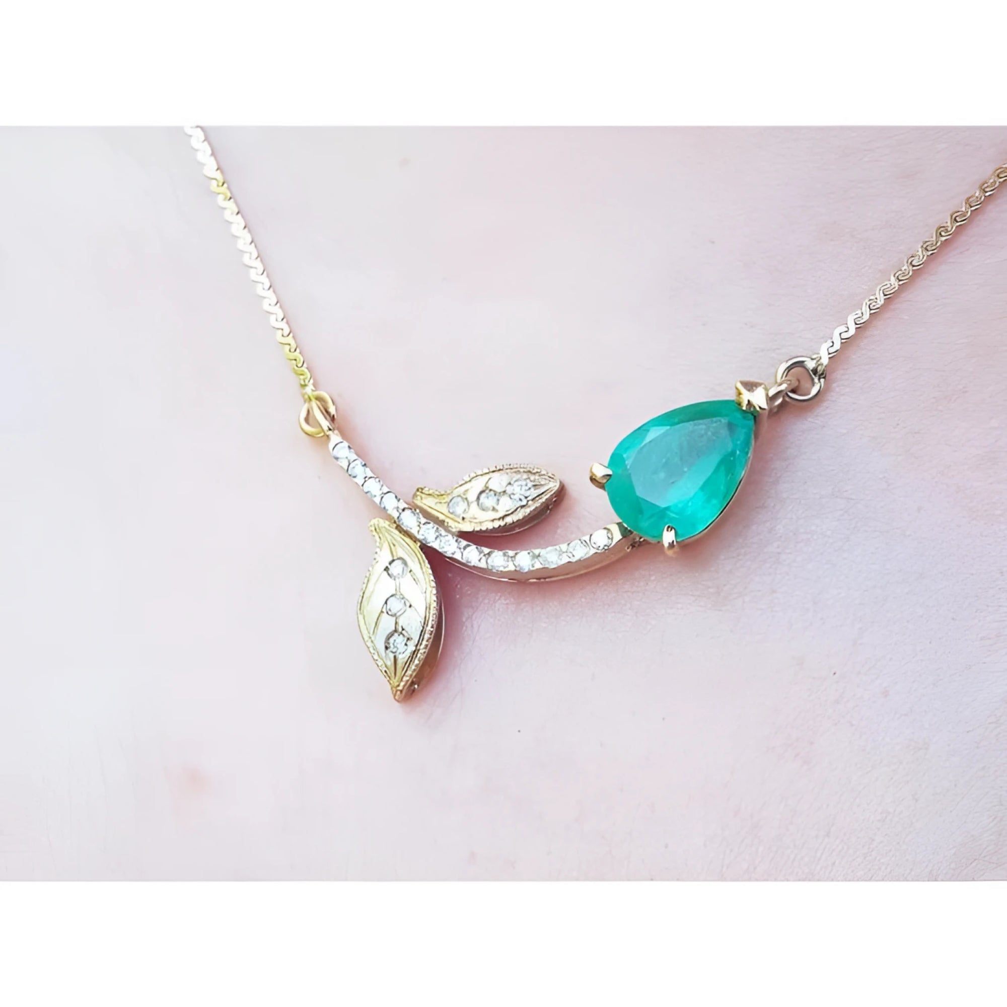14K yellow gold twig necklace with a pear-cut natural emerald and diamond accents.