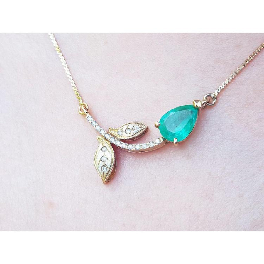 14K yellow gold twig necklace with a pear-cut natural emerald and diamond accents.