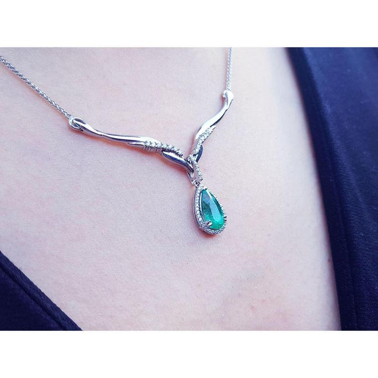 1.28 carat pear cut emerald necklace in 14K white gold with diamond accents and chevron design.