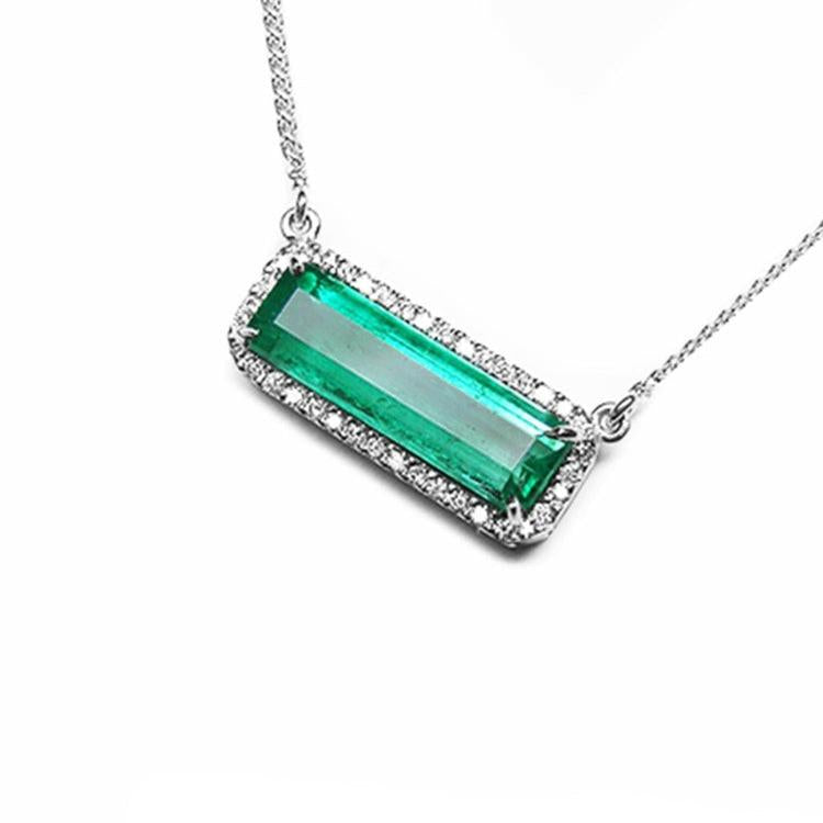 18K white gold necklace with a rectangular Colombian emerald and diamond halo, East-West design.