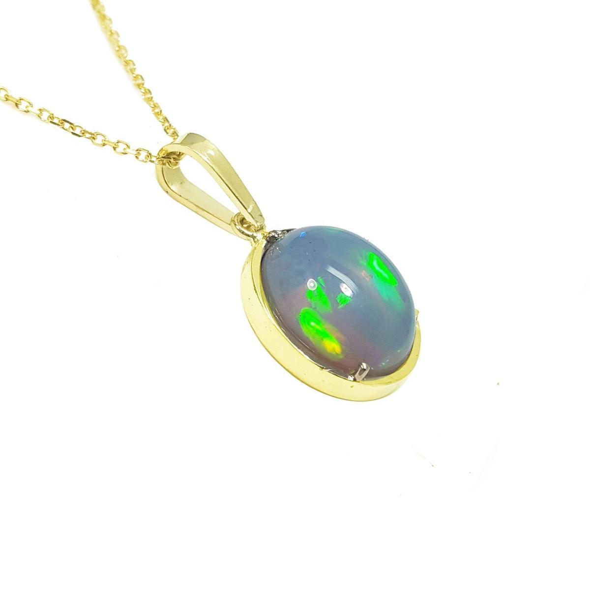 Right side profile view of a opal pendant with gold setting on a white background.