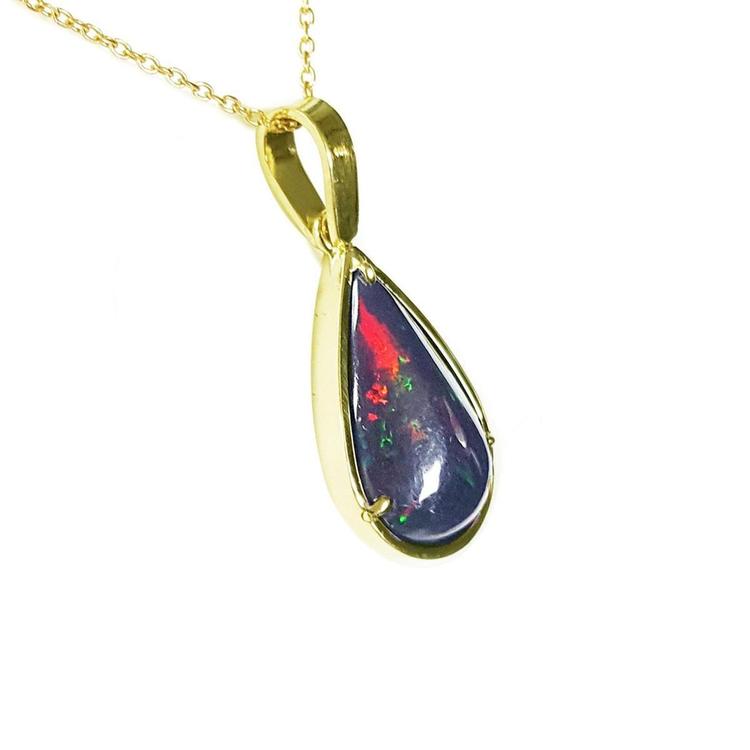 Teardrop Welo black opal pendant with red-orange and blue-green flashes in 14K yellow gold.