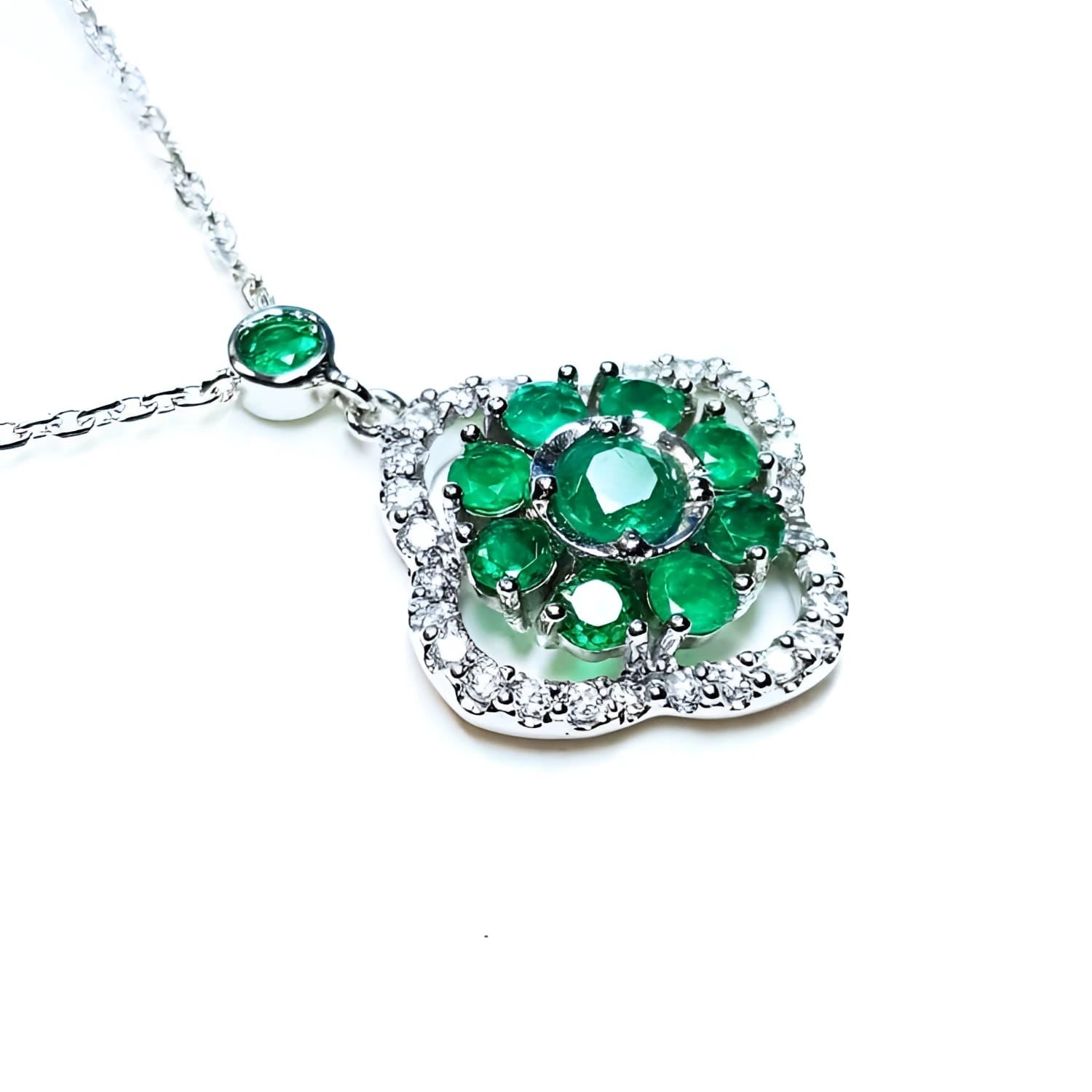 A 14k white gold necklace with genuine round cut colombian emeralds cluster pendant.
