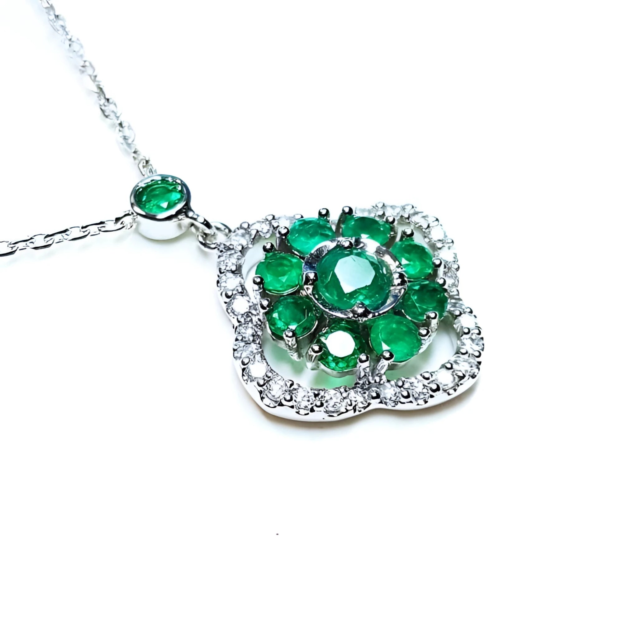 A 14k white gold necklace with genuine round cut colombian emeralds cluster pendant.