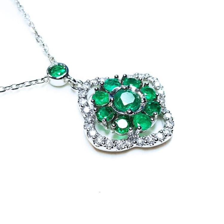 A 14k white gold necklace with genuine round cut colombian emeralds cluster pendant.