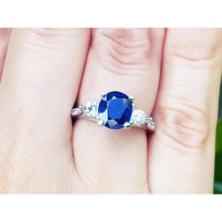 Women's natural blue sapphire ring side diamonds three stone white gold, on a finger's person