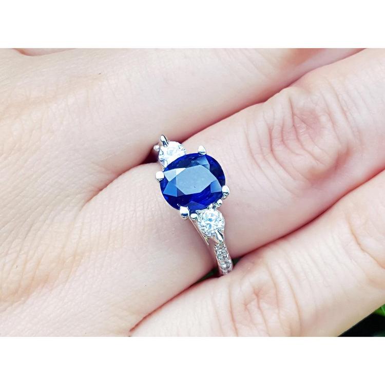 Women's natural blue sapphire ring side diamonds three stone white gold, on a woman's hand