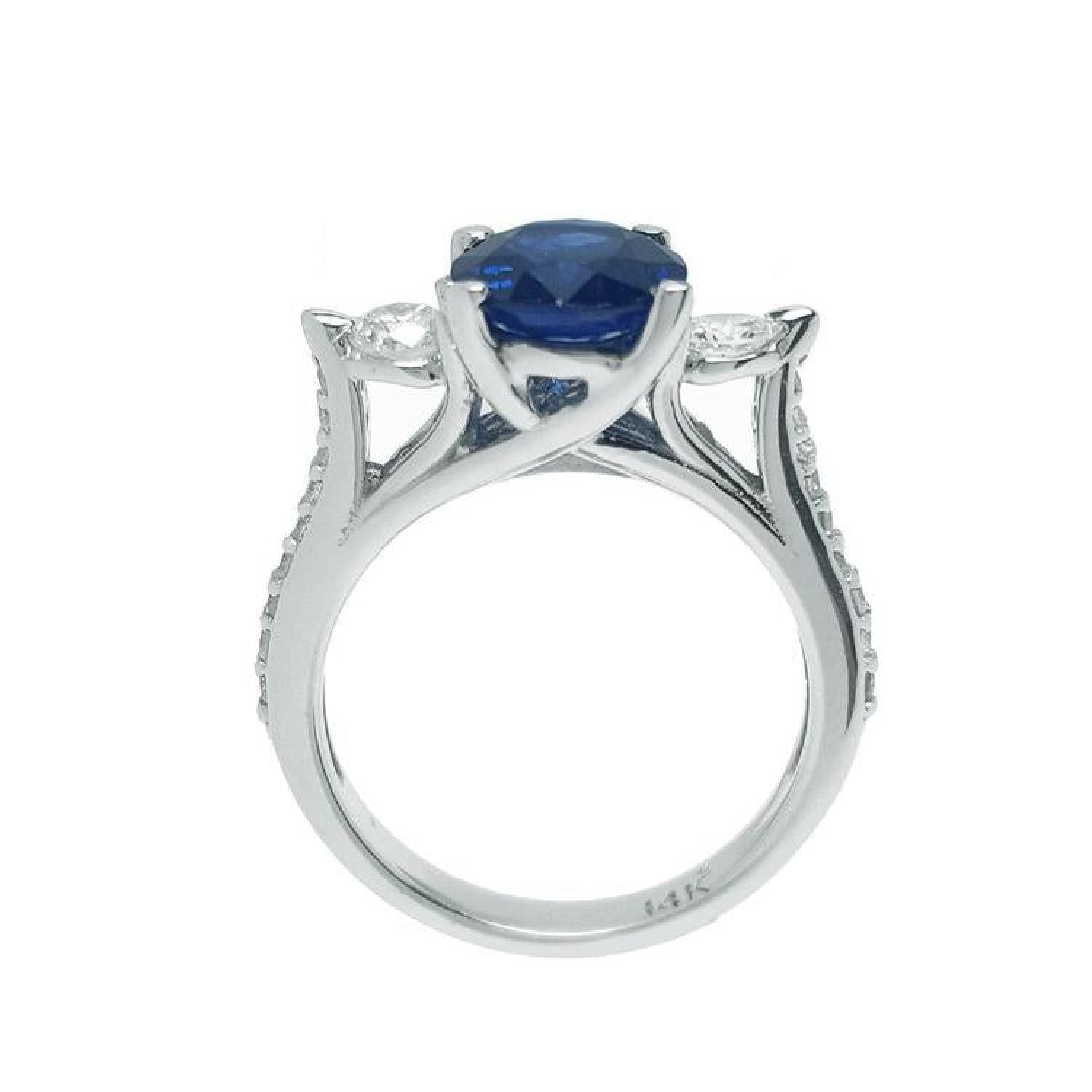14K white gold ring with a deep blue oval sapphire and side diamonds.