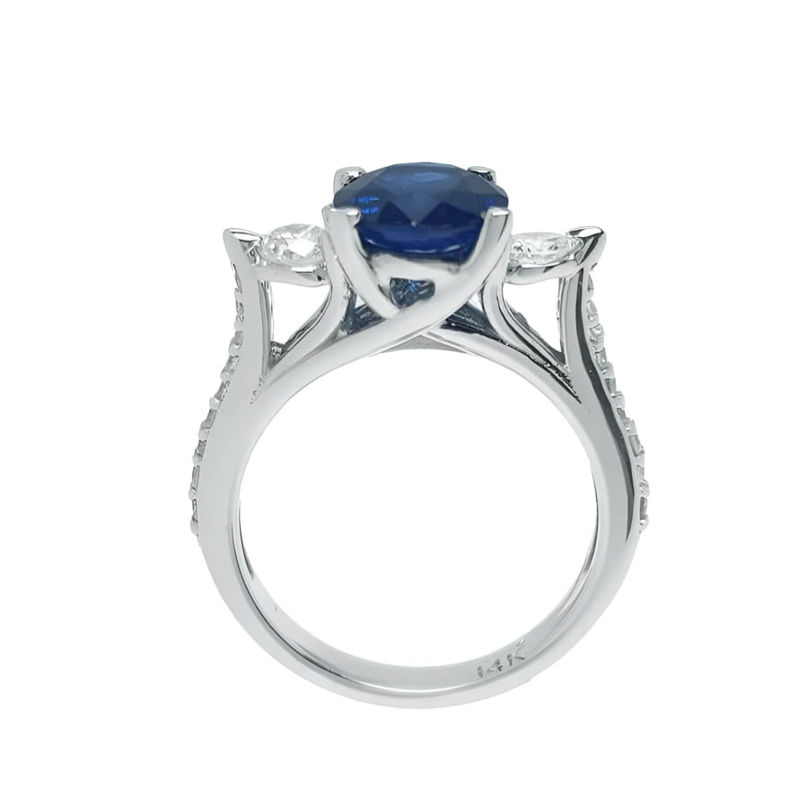 14K white gold ring with a deep blue oval sapphire and side diamonds.