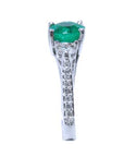 A round cut emerald ring displaying on top the main gemstone and side band ring with diamonds profile.