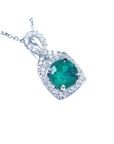 Round cut emerald pendant with natural halo diamond accents made of 18k white gold.