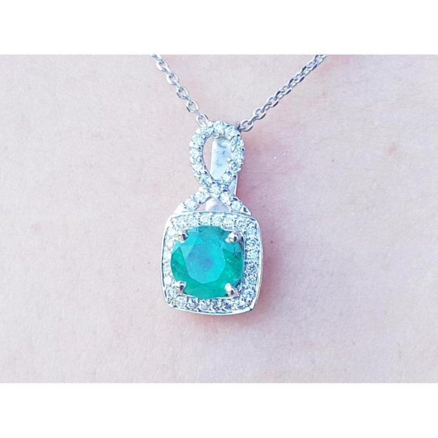 1.08 ct. round emerald and diamond pendant in 18K white gold, featuring a deep bluish-green emerald.