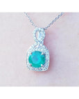 1.08 ct. round emerald and diamond pendant in 18K white gold, featuring a deep bluish-green emerald.