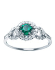 This women's ring features a Colombian emerald with a round cut, surrounded by a halo of natural diamonds.