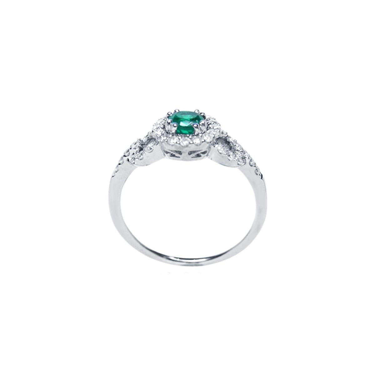 A detailed view of the round cut emerald with a halo diamond ring, highlighting the top, side gallery, and band.