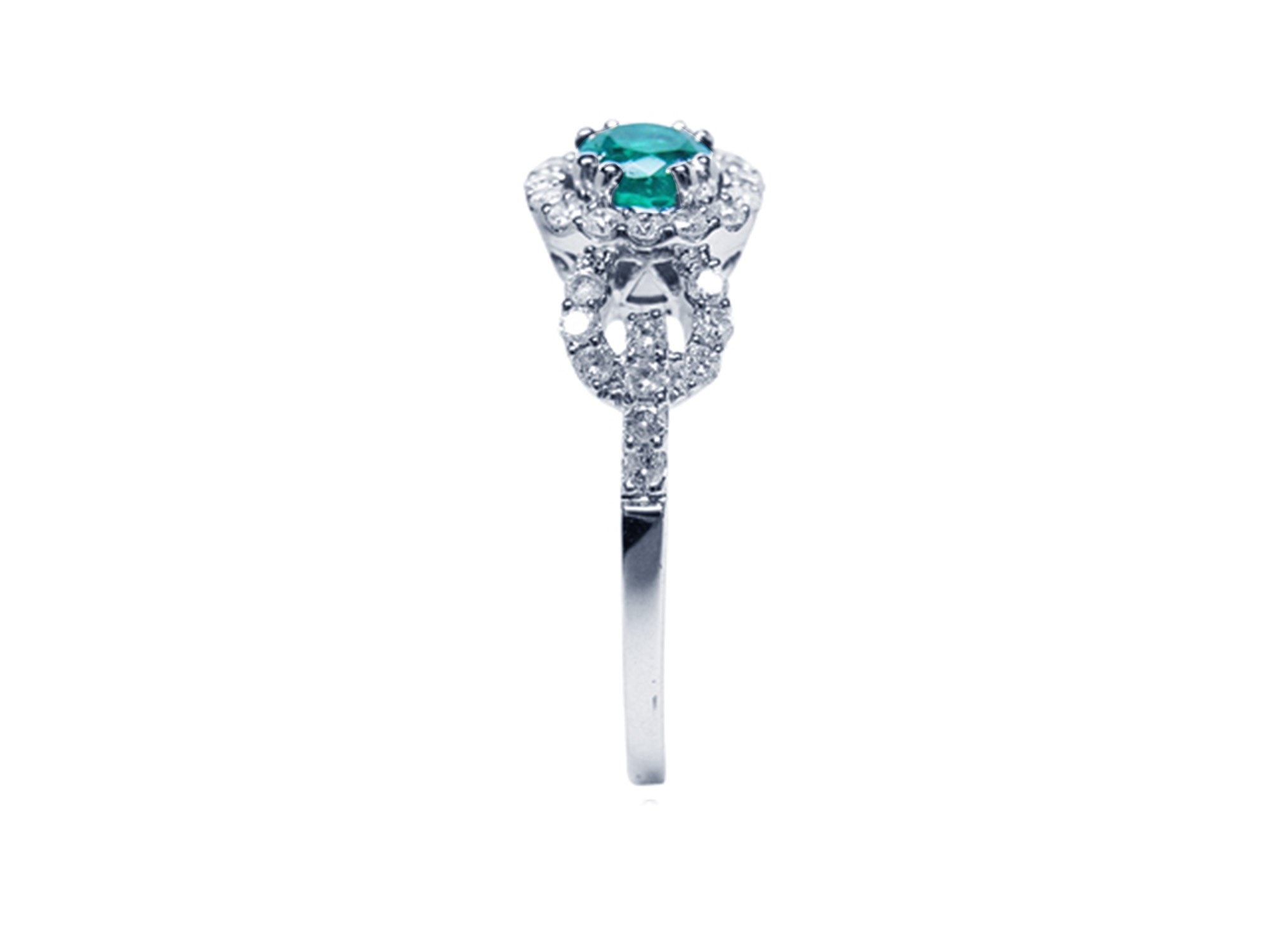 Showcasing the top emerald setting, gallery, and band of a round cut emerald ring in white gold.