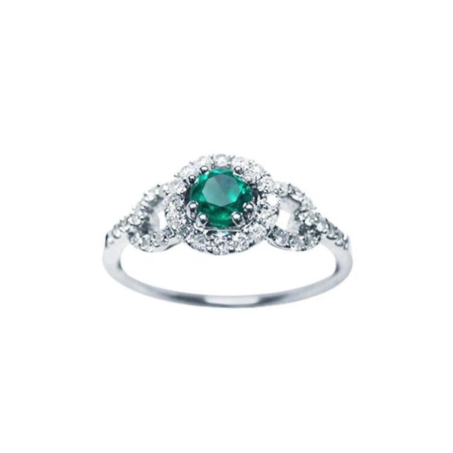 This women's ring features a Colombian emerald with a round cut, surrounded by a halo of natural diamonds.