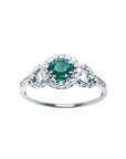 This women's ring features a Colombian emerald with a round cut, surrounded by a halo of natural diamonds.