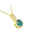 A 14k yellow gold round cut emerald pendant necklace surrounded by a halo of natural diamonds.