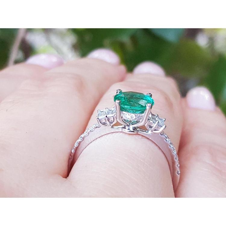 1.10 ct. round Colombian emerald ring with baguette side diamonds in 14K white gold.