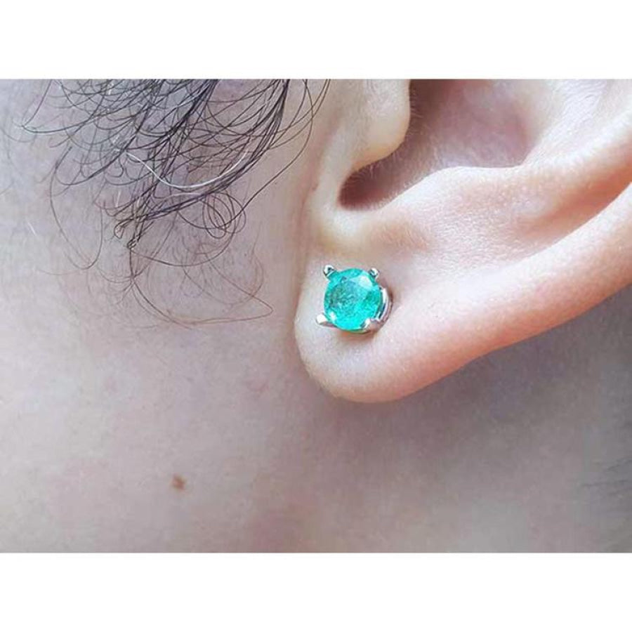 Round-cut Colombian emerald stud earring in 14k white gold, worn on an ear.