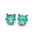 Pair of emerald stud earrings on a front side position top view.