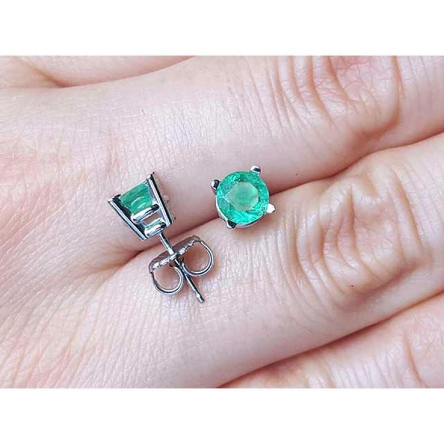 Round 0.89 ct. green emerald stud earrings in 14k white gold, displayed on a hand.