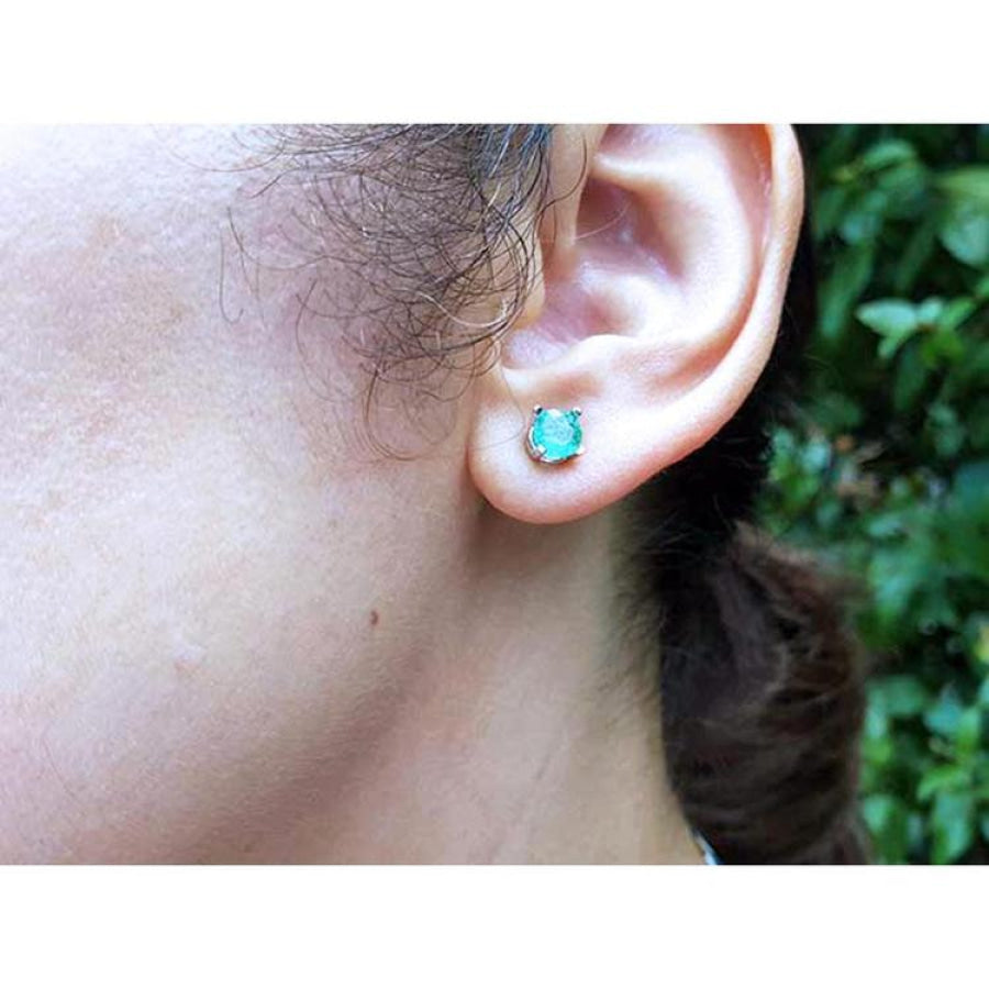 Round 0.89 ct. Colombian emerald stud earring in 14k white gold worn on an ear.