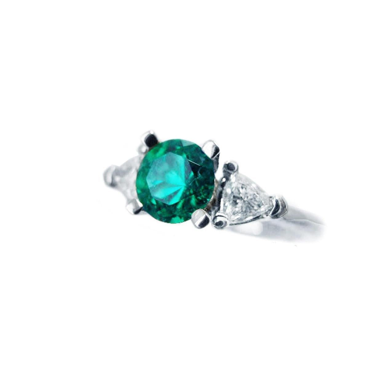 A natural emerald ring round cut with trillion side diamonds displaying its left side profile.