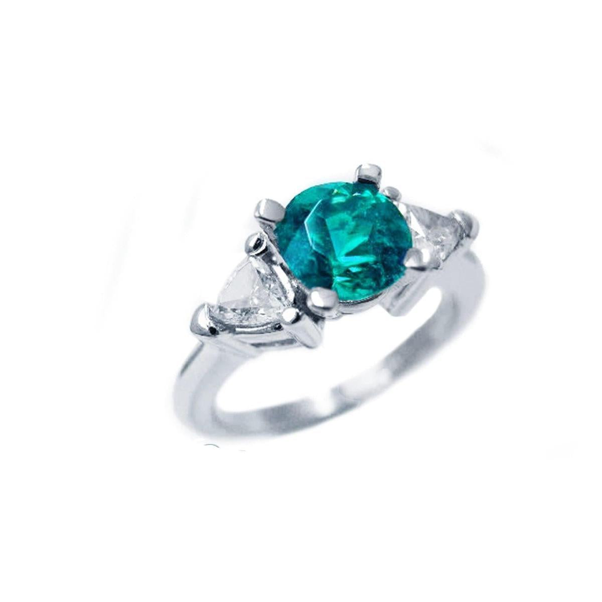 This natural emerald ring round cut with trillion side diamonds displays its top and right-side profile.