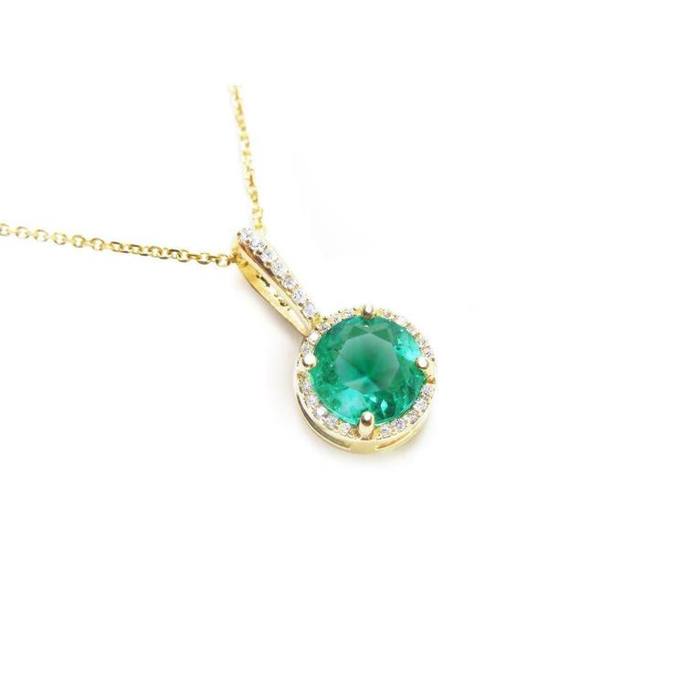 A round cut natural colombian emerald pendant necklace in yellow gold displaying its topside view.
