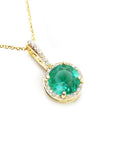 A round cut natural colombian emerald pendant necklace in yellow gold displaying its topside view.