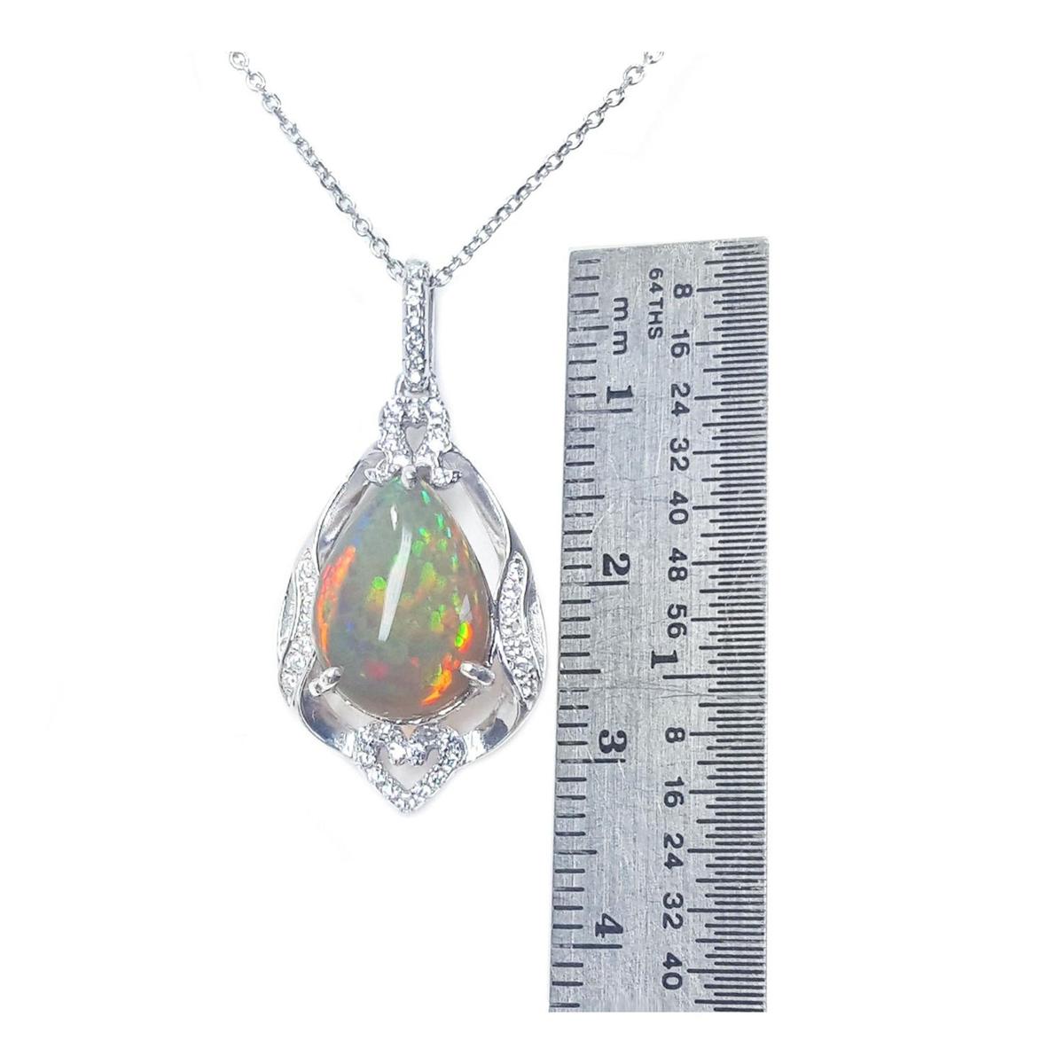 Opal pendant necklace with a ruler for scale on a white background.