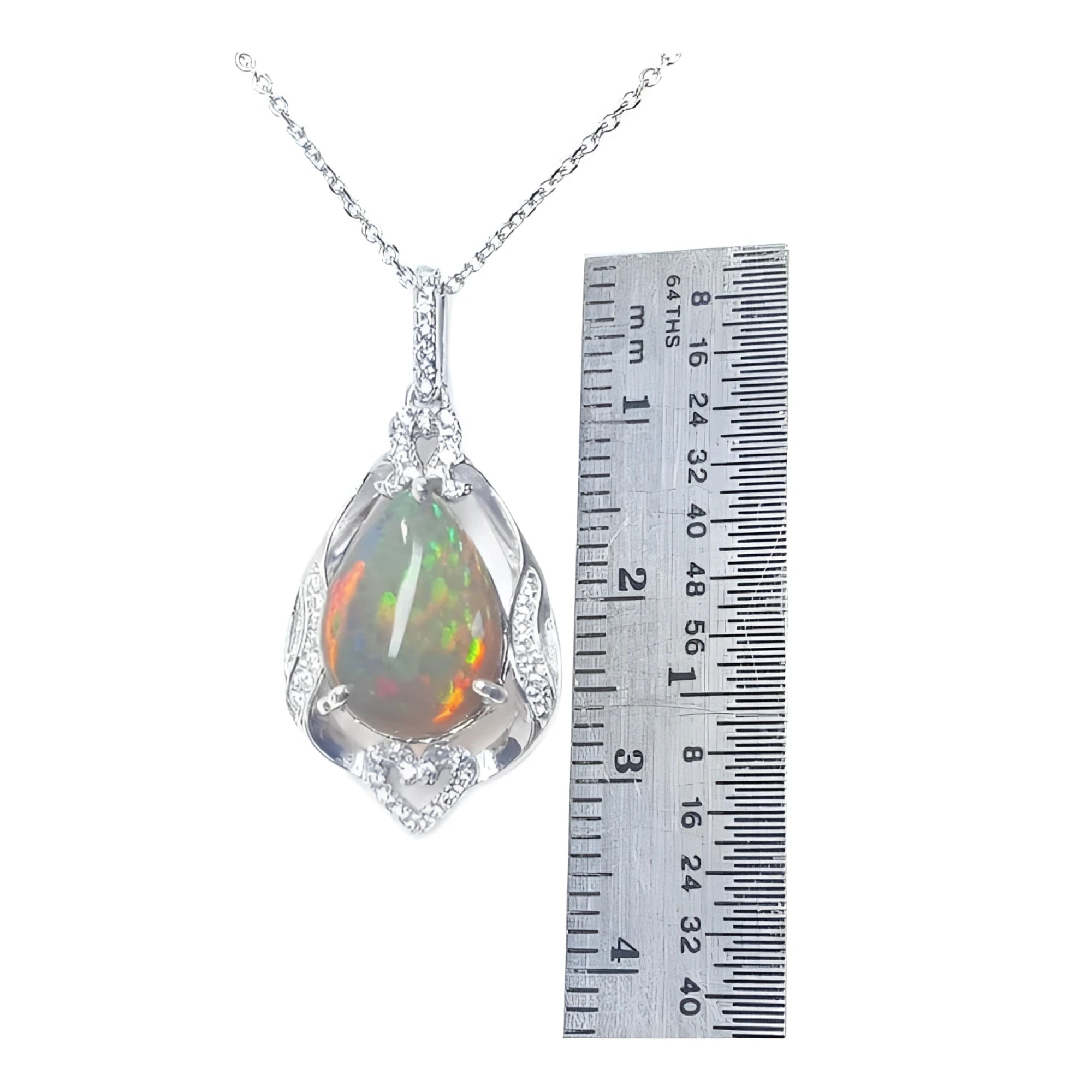 Pear-shaped Welo Ethiopian opal pendant in sterling silver with CZ accents, next to a ruler.