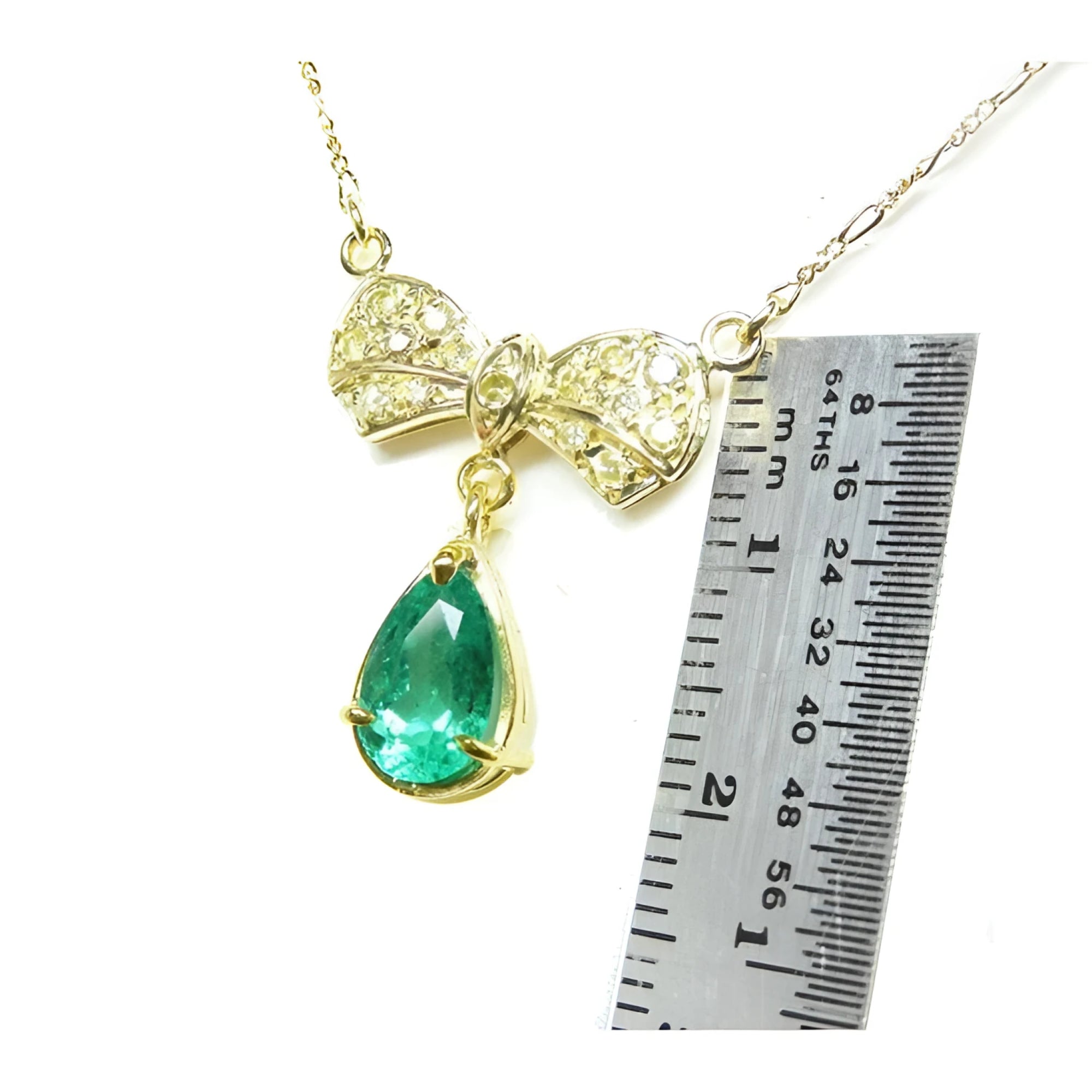 18K yellow gold bow-tie necklace with pave diamonds and a dangling pear-shaped emerald.