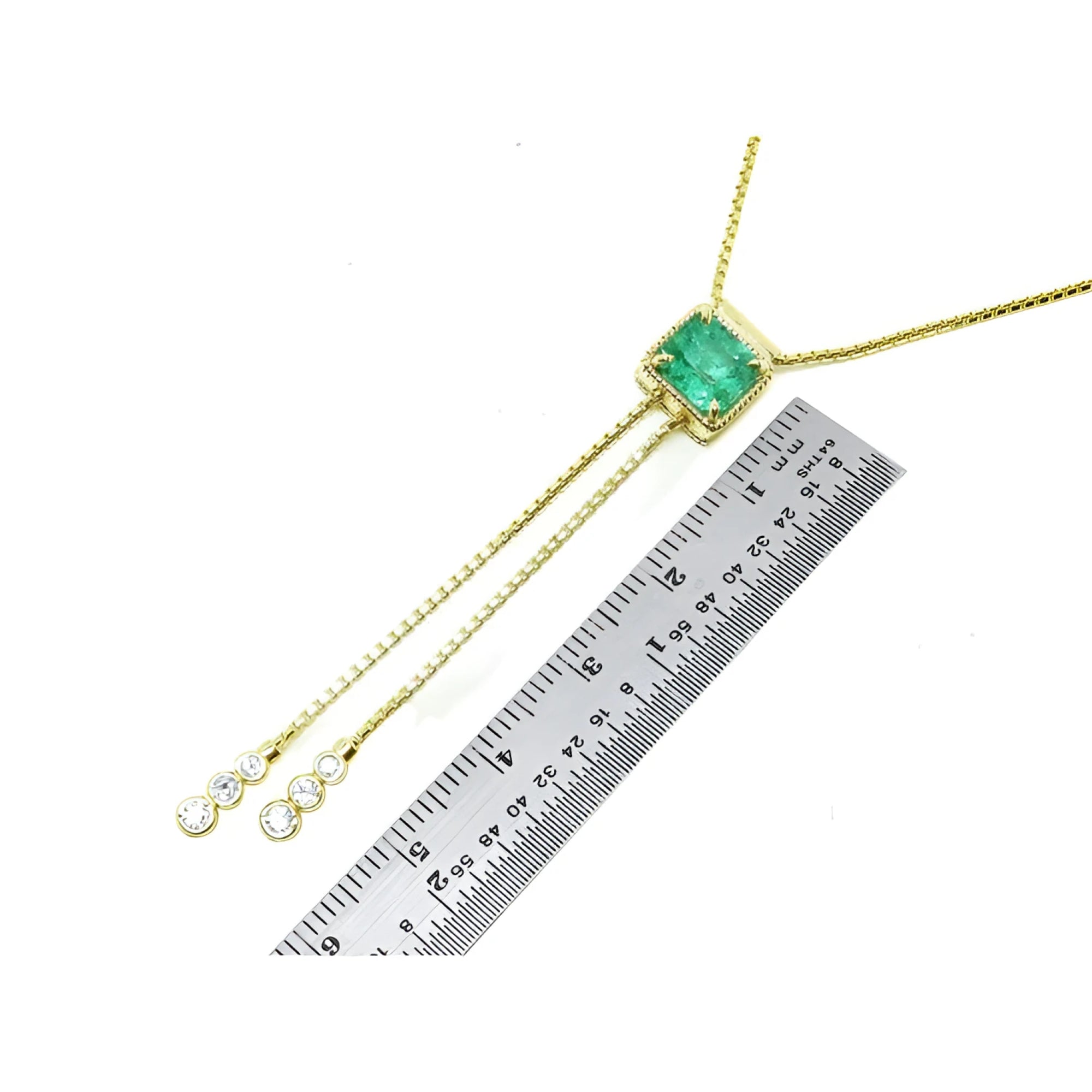 Emerald lariat necklace with an emerald-cut natural emerald, milgrain, and prong-set diamonds on a gold box chain.