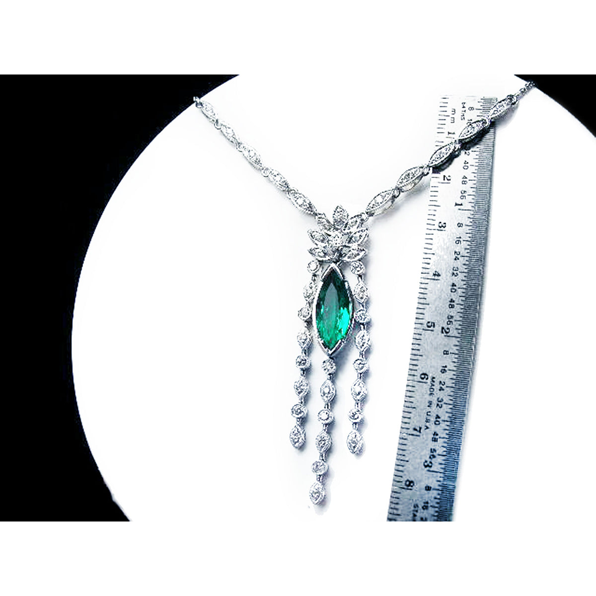 Marquise necklace 2.12 carats Colombian emerald and diamonds 14K white gold next to a ruler for measuring size