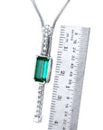 White gold necklace with a rectangular Colombian emerald and diamond accents, shown next to a ruler.