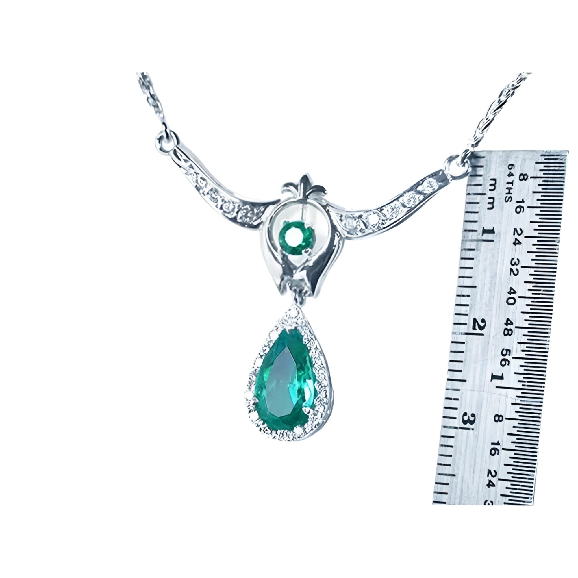 1.67 ct. pear emerald necklace with diamonds in 14K white gold, shown with a ruler for size.
